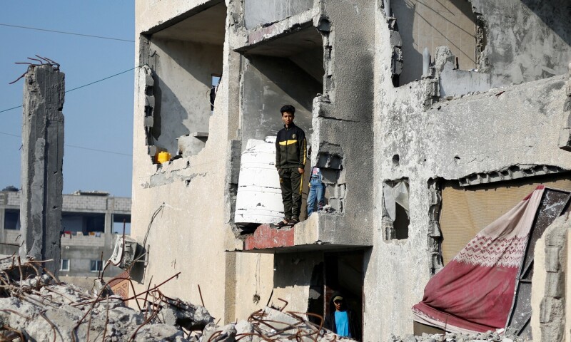 Palestinians stand in a house destroyed by an Israeli strike, in Rafah, southern Gaza Strip, on Jan 1, 2024. — Reuters