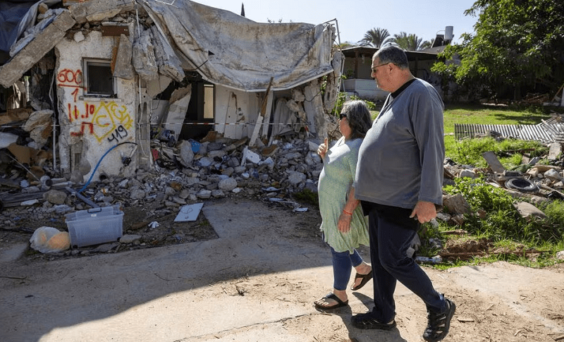  Ayelet Khon and Shar Shnurman walk past the remains of a home that was destroyed in Oct 7 attack in Kibbutz Kfar Aza in southern Israel, January 13, 2024.&mdash; Reuters