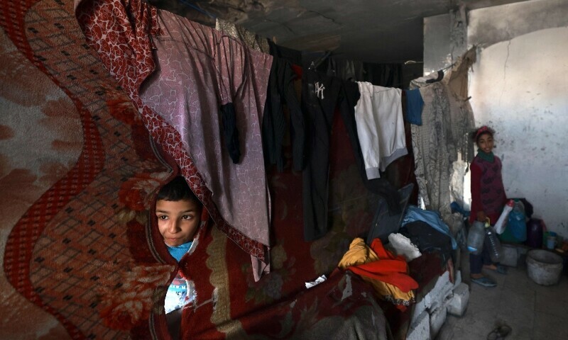 Displaced Palestinian children pose for a picture as they shelter with their family inside a building damaged during Israeli bombardment in Rafah in the southern Gaza Strip on January 17, 2024. &mdash; AFP