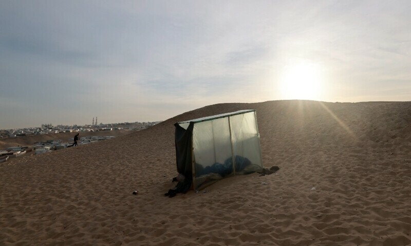 A displaced Palestinian sleeps in a makeshift tent at a camp in Rafah near the border with Egypt in the southern Gaza Strip, on January 21. &mdash; AFP