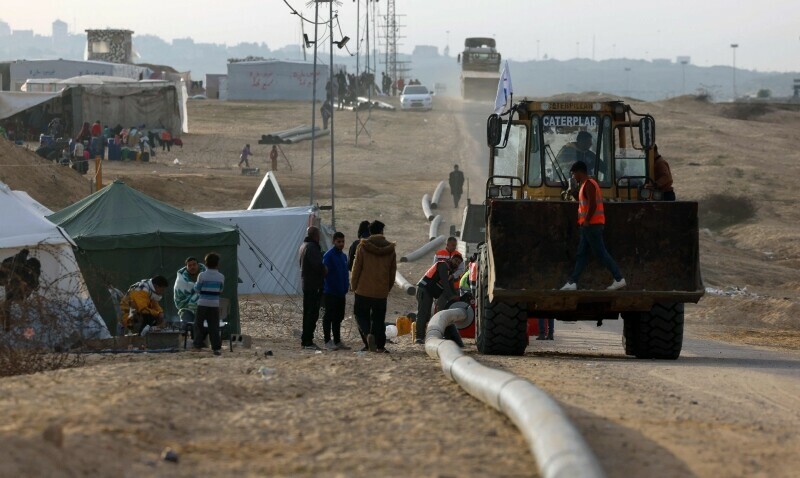 Water utility personnel set-up a water-pumping system for displaced Palestinians at a makeshift tent camp in Rafah near the border with Egypt in the southern Gaza Strip, on January 21. &mdash; AFP