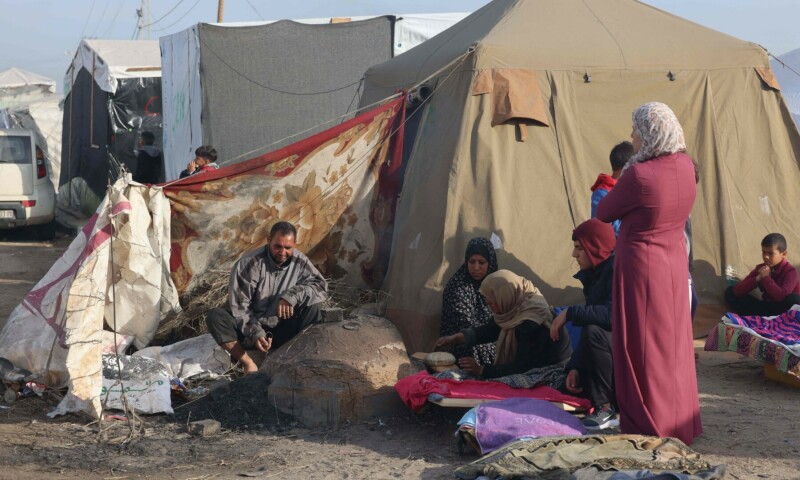 Displaced Palestinians bake bread in a traditional clay oven near their tent at a makeshift camp in Rafah near the border with Egypt in the southern Gaza Strip on January 21, 2024. &mdash; AFP