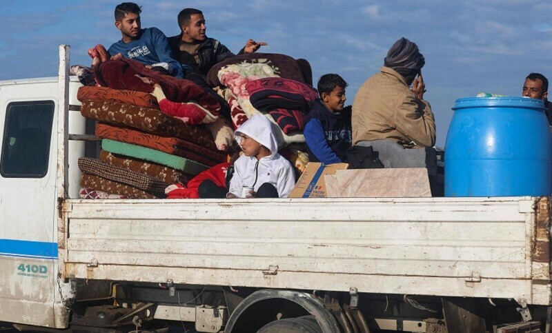 Palestinians arrive from Khan Yunis in a pick-up truck loaded with their belongings, to a makeshift tent camp for displaced people in Rafah on Jan 24. &mdash; AFP