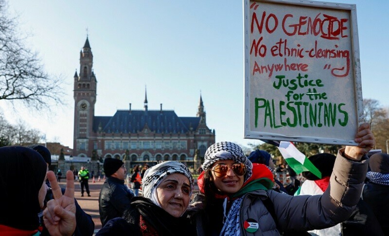 Pro-Palestinian protesters pose for a photo in front of the ICJ as judges rule on emergency measures against Israel, in The Hague, Netherlands on January 26, 2024. &mdash; Reuters