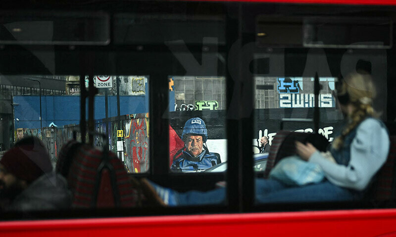A bus drives past a graffiti made by Spanish street artist Nacho Welles, also known as Core246, depicting Palestinian journalist and bureau chief of Al Jazeera in Gaza City Wael al-Dahdouh, as part of a project launched by the art platform Creative Debuts called &ldquo;Heroes of Palestine&rdquo;, in east London, on January 29. &mdash; AFP
