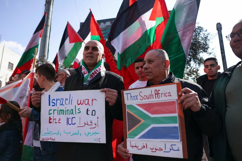 Protesters lift placards and national flags at a rally supporting Palestinians in Gaza in Hebron&rsquo;s city center in the Israel-occupied West Bank on February 25. &mdash; AFP
