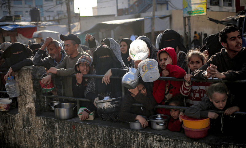 Displaced Palestinians gather to collect food donated by a charity before an iftar meal in Rafah on March 11, 2024. — AFP