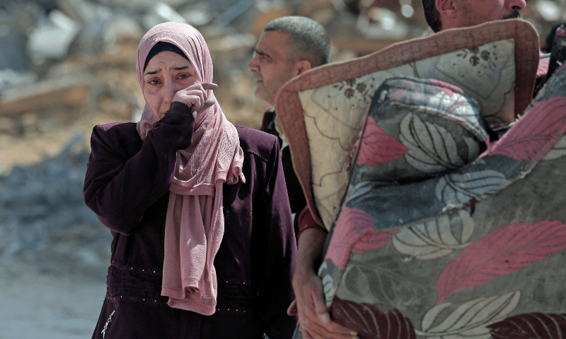  A displaced Palestinian woman weeps while walking through a street amid the rubble of houses destroyed by Israeli bombardment in Hamad area, west of Khan Younis in the southern Gaza Strip on March 14, 2024. &mdash; AFP 