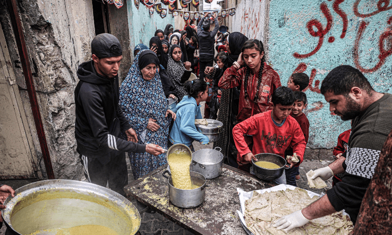  Displaced Palestinians queue to receive food donated by a charity organisation ahead of iftar during Ramazan, in Rafah in the southern Gaza Strip on March 16, 2024. &mdash; AFP 