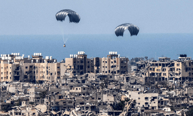  This picture taken from Israel&rsquo;s southern border with the Gaza Strip shows parachutes of humanitarian aid dropping over the besieged Palestinian territory on March 26. &mdash; AFP