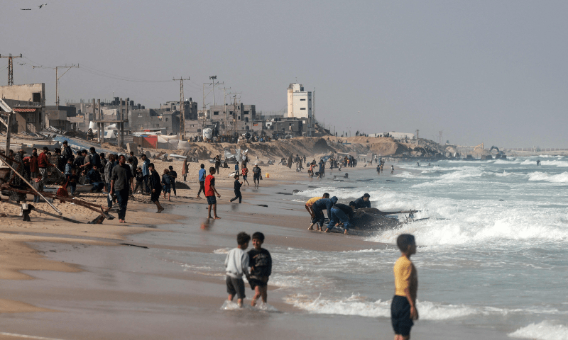 Palestinians gather along a beach adjoining a makeshift camp for displaced people in Rafah in the southern Gaza Strip on March 30. — AFP