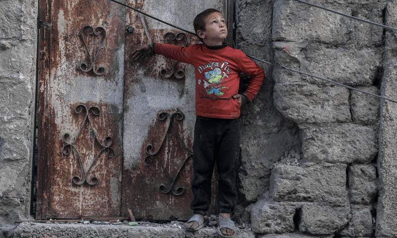  A Palestinian boy looks at a drone in the sky in the southern Gaza Strip city of Rafah on April 2. &mdash; AFP 