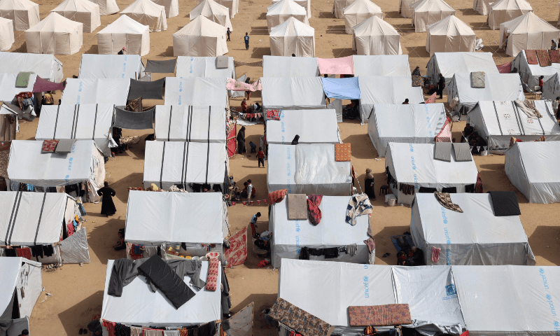  Displaced Palestinians stand outside tents at a makeshift camp in Rafah in the southern Gaza Strip on March 27. &mdash; AFP 