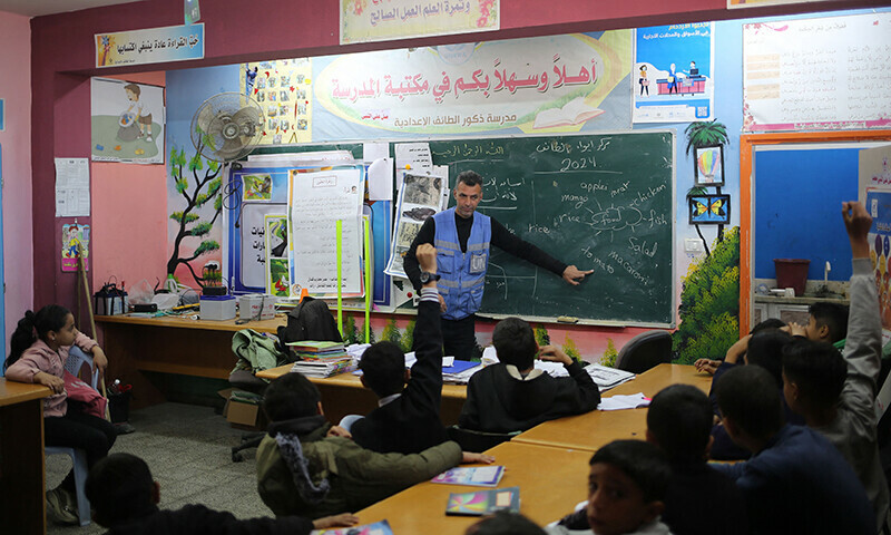 Ismail Wahba, director of the UNRWA Taif School in Rafah, teaches an English class in the library of the school housing displaced Palestinians, in Rafah in the southern Gaza Strip on March 4, 2024.&mdash;AFP