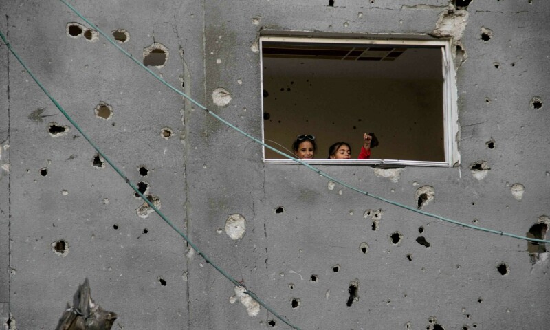 Palestinian children look on from a window during Eidul Fitr in Gaza City on April 11. &mdash; Reuters
