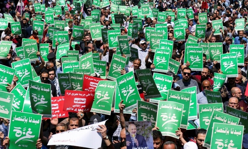Demonstrators carry flags and banners during a protest in support of Palestinians in Gaza in Amman, Jordan on April 12. The green banners read: &lsquo;Our Eid is with the victory of Gaza&rsquo;. &mdash; Reuters