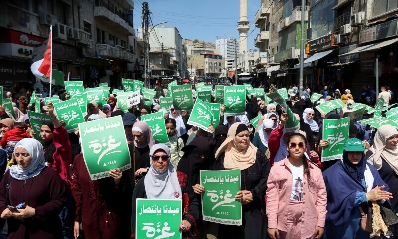 Demonstrators carry flags and banners during a protest in support of Palestinians in Gaza in Amman, Jordan on April 12. The green banners read: &lsquo;Our Eid is with the victory of Gaza&rsquo;. &mdash; Reuters