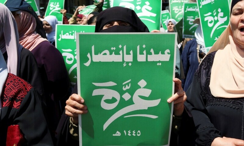 Demonstrators carry flags and banners during a protest in support of Palestinians in Gaza in Amman, Jordan on April 12. The green banners read: &lsquo;Our Eid is with the victory of Gaza&rsquo;. &mdash; Reuters