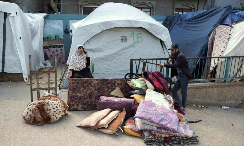Palestinians gather belongings as people fleeing conflict leave their homes, in the Nuseirat refugee camp in central Gaza on April 12. &mdash; AFP