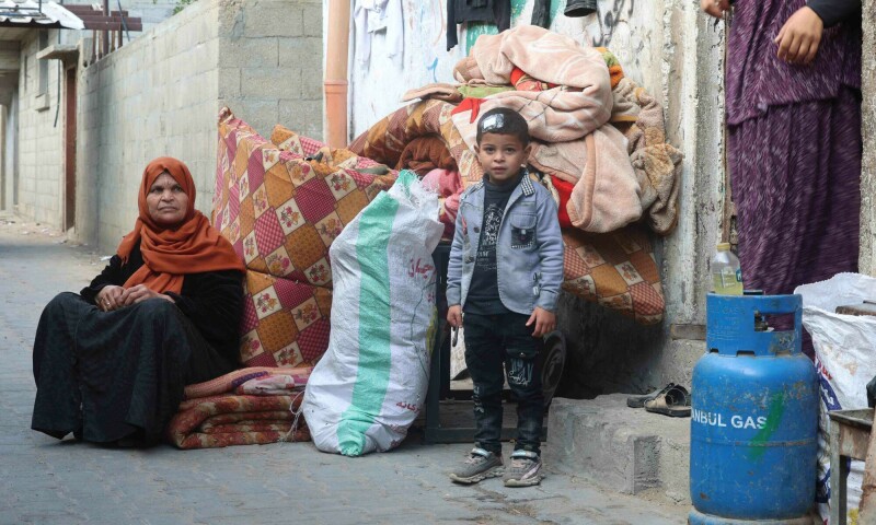 Palestinians gather belongings as people fleeing conflict leave their homes, in the Nuseirat refugee camp in central Gaza on April 12. &mdash; AFP