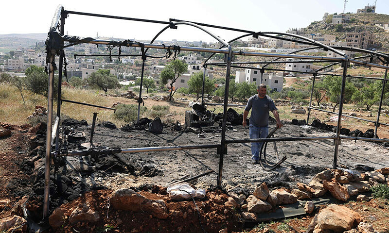 A Palestinian inspects the damage in the village of Mughayir in the Israeli-occupied West Bank on April 13, 2024. &mdash; AFP