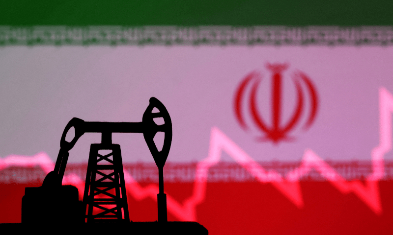  Iranian flag with stock graph and an oil pump jack miniature model. &mdash; Reuters