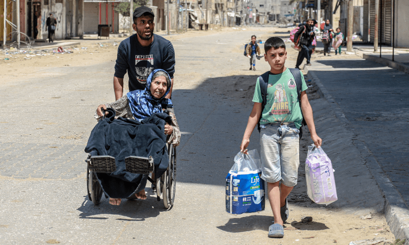  Palestinians carrying their personal belongings flee their homes in the city of Nuseirat in the central Gaza Strip on April 17. &mdash; AFP 