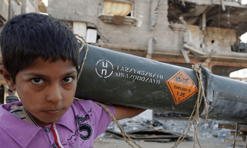 Palestinian child carries an empty US ammunition container in Khan Younis in the southern Gaza Strip on May 16, 2024. — AFP