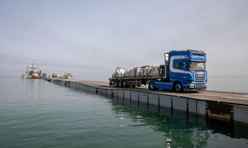  A truck carries humanitarian aid across Trident Pier, a temporary pier to deliver aid, off the Gaza Strip, near the Gaza coast on May 19. &mdash; Reuters 