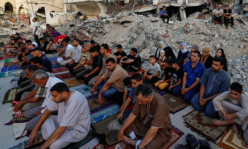Palestinians hold Eidul Azha prayers by the ruins of Al-Rahma mosque in Khan Younis, in the southern Gaza Strip on June 16. &mdash; Reuters