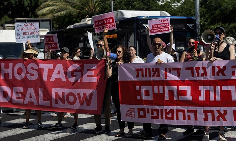  People hold up signs and banners during a demonstration in Tel Aviv calling for the immediate return of hostages held in Gaza on June 26. &mdash; Reuters 
