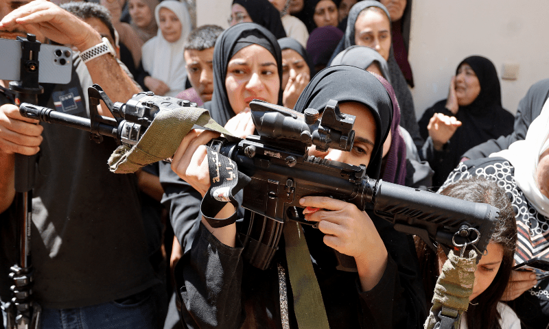  Haneen, sister of Mohammad Shehada who was killed in an Israeli airstrike, kisses his rifle during the funeral of four Palestinians in Nour Shams camp, in Tulkarm, in the Israeli-occupied West Bank on July 3, 2024. &mdash; Reuters 