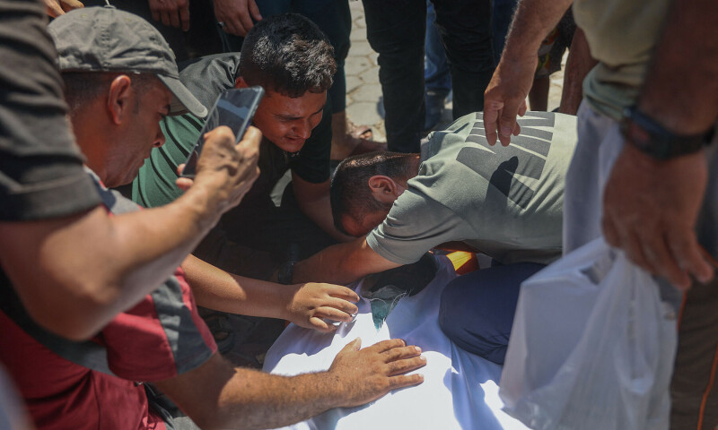 Palestinians mourn by the bodies of relatives killed in an Israeli strike which hit a makeshift prayer hall at al-Shati refugee camp west of Gaza City on July 13, 2024.&mdash;AFP