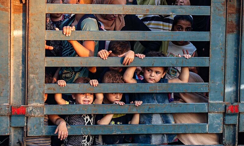 Children look on from the back of a truck as Palestinians flee the al-Bureij refugee camp in the central Gaza Strip on July 28. &mdash; AFP