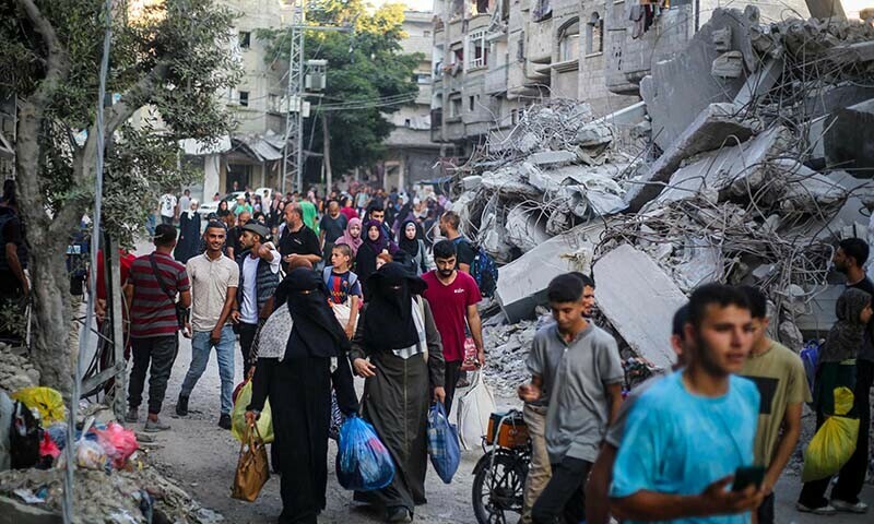 Palestinians carrying their personal belongings flee the al-Bureij refugee camp in the central Gaza Strip on July 28. &mdash; AFP