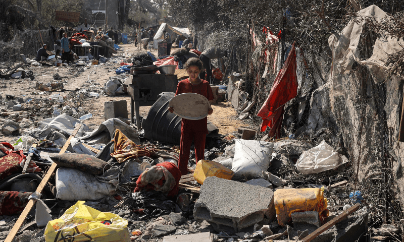  A Palestinian girl recovers a tray from items scattered on the floor in Deir el-Balah in the central Gaza Strip, on Aug 7. &mdash; AFP 