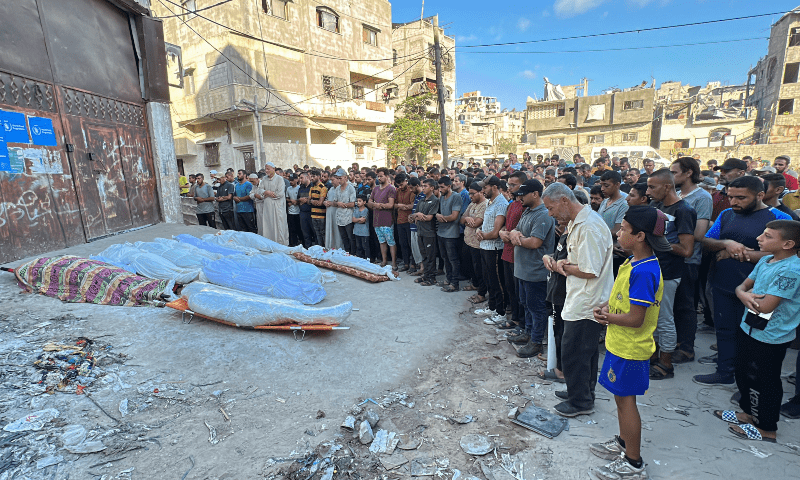 Palestinians pray next to the bodies of Palestinians killed in an Israeli strike on a school sheltering displaced people, in Gaza City on Aug 10, 2024. — Reuters