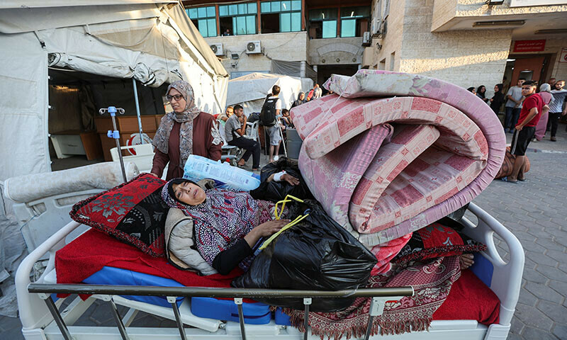 A woman lies down as Palestinian patients fearing an Israeli ground operation, flee Al-Aqsa Martyrs hospital, after Israeli army ordered the evacuation of nearby areas in Deir Al-Balah in the central Gaza Strip August 25. — Reuters