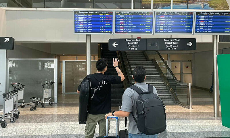 This picture shows passengers checking the departures board at Beirut International airport on September 27. — AFP