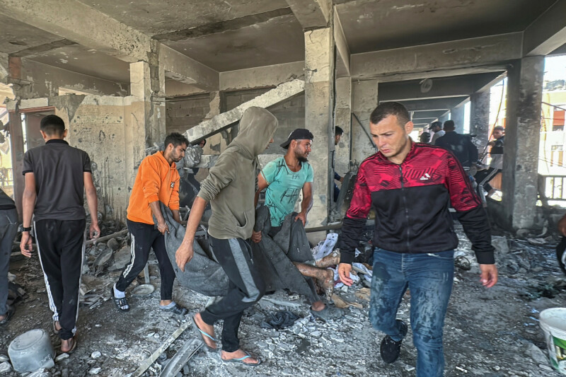 People carry the dead body of a Palestinian killed in an Israeli strike at a school sheltering displaced people, amid the Israeli invasion of Gaza, in Nuseirat in the central Gaza Strip, October 24. &mdash; Rueters