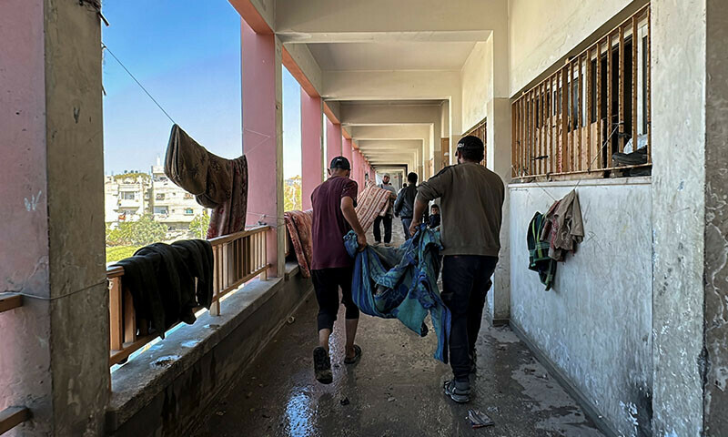 People carry the dead body of a Palestinian killed in an Israeli strike at a school sheltering displaced people, amid the Israeli invasion of Gaza, in Nuseirat in the central Gaza Strip, October 24. &mdash; Rueters
