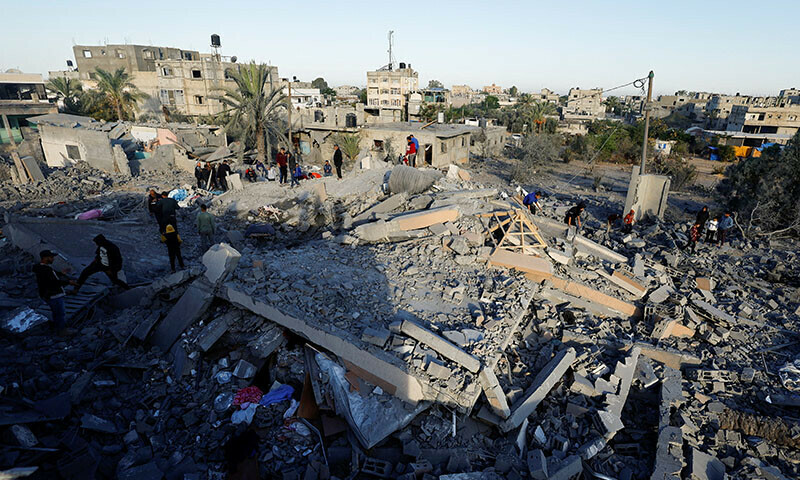 Palestinians inspect the site of an Israeli strike on a house, in Khan Younis in the southern Gaza Strip on October 25. — Reuters