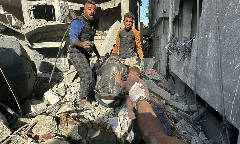Palestinians remove a body from the rubble of a building hit by an Israeli strike in Beit Lahia, in the northern Gaza Strip, on October 29. — AFP