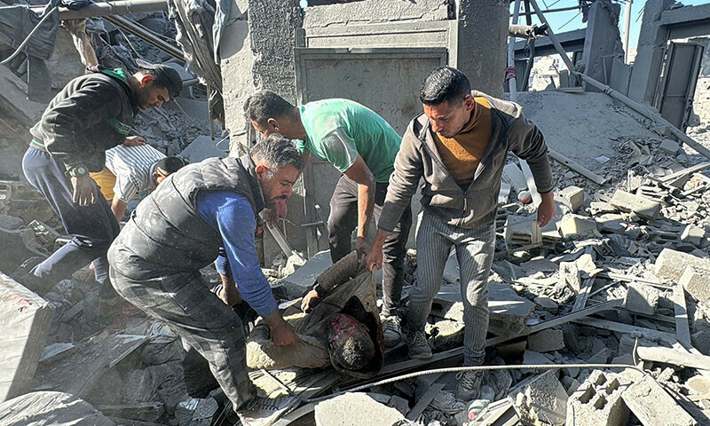 Palestinians remove a body from the rubble of a building hit by an Israeli strike in Beit Lahia, in the northern Gaza Strip, on October 29. — AFP