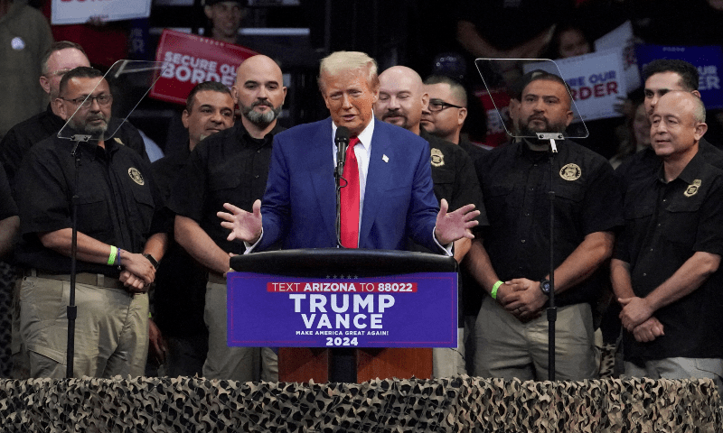 Donald Trump speaks as members of National Border Patrol Council stand next to him during a campaign rally in Prescott Valley, Arizona, US on October 13. — Reuters