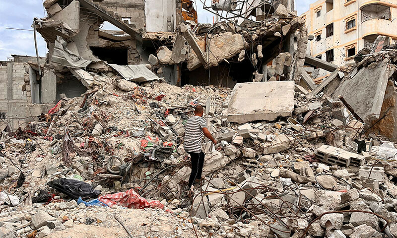 Palestinian man Moein Abu Odeh searches for clothes through the rubble of a house destroyed in the Israeli military offensive, in Khan Younis in the southern Gaza Strip on November 18. &mdash; Reuters