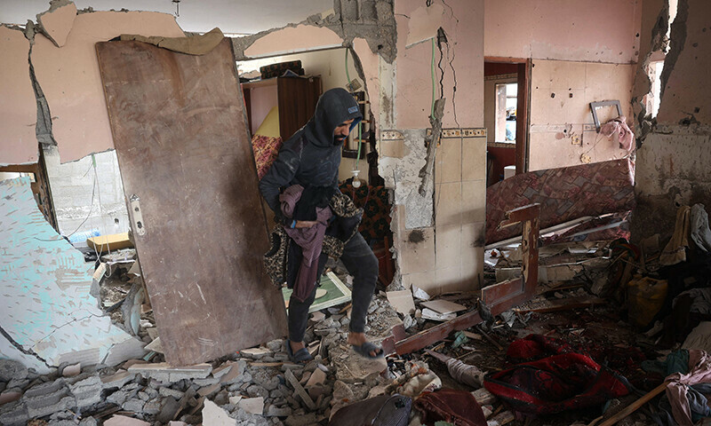 A Palestinian man checks the destruction in a house after an Israeli strike in the Nuseirat camp in the central Gaza Strip, on December 10. — AFP