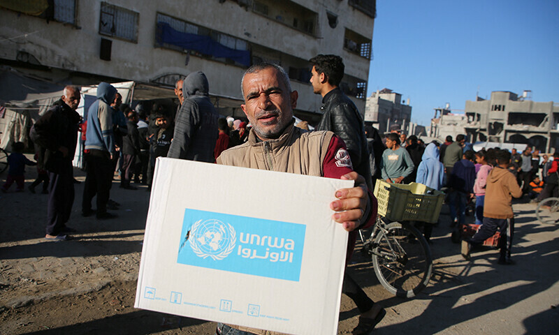 A Palestinian man carries an aid box provided by UNRWA, following a ceasefire between Israel and Hamas, in Khan Younis in the southern Gaza Strip, January 21. &mdash; Reuters