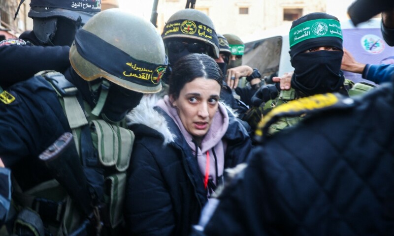  Palestinian group Islamic Jihad and Hamas fighters escort Israeli hostage Arbel Yehud (C) to hand her over to a Red Cross team Khan Yunis on January 30, as part of their third hostage-prisoner exchange. &mdash; AFP 