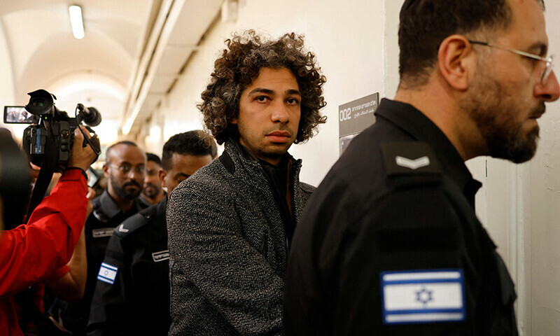Palestinian bookseller Ahmad Muna is escorted by Israeli police into court in Jerusalem on February 10. — AFP